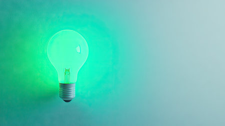 A glowing green light bulb on a soft background, symbolizing creativity and innovation. Ideal for concepts related to energy, design, and modern technology.の素材