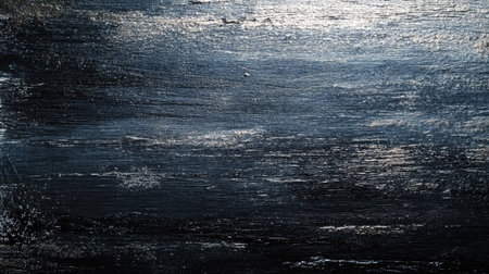 A dark and textured surface featuring subtle light reflections, perfect for creating a moody and artistic atmosphere in designs and projects.の素材