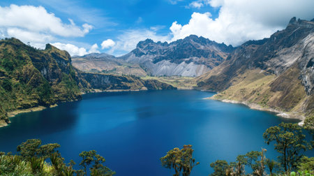 A stunning view of a serene mountain lake surrounded by majestic peaks and vibrant blue skies, offering a tranquil escape into natureの素材