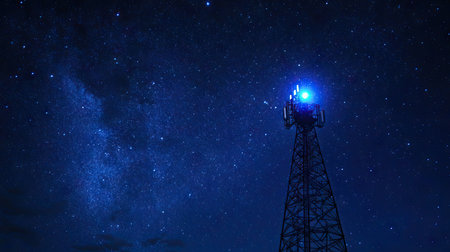 A signal tower with neon blue lights, standing out against a starry night sky.の素材