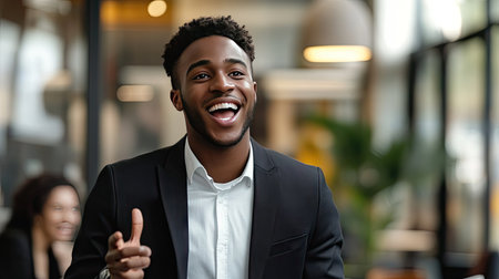 A young businessman excitedly presenting a business plan to colleagues in a modern office.の素材