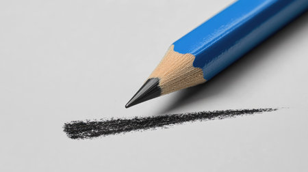 Blue pencil with black lead making precise strokes across a white-gray background. Minimalist design concept for back-to-school, art, and creative work.の素材