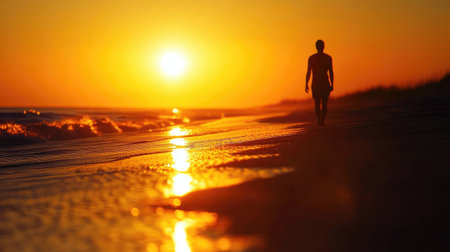 A close-up of the sun setting behind a tranquil beach, with the silhouette of a lone figure walking along the shoreline, adding a sense of calm and solitude to the sunset.の素材