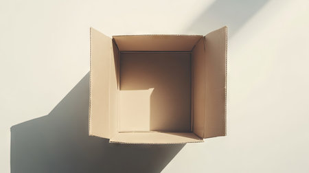 A flat lay view of a cardboard box with slightly open flaps on a white background, perfect for illustrating packing, moving, or shipping conceptsの素材
