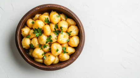 A rustic brown bowl filled with delicious, golden-brown potatoes garnished with fresh parsley, perfect for a cozy meal or snack. Ideal for rustic cuisine.の素材