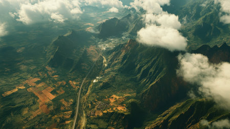 Stunning aerial view showcasing the Laos and China railway amidst dramatic landscapes, featuring lush mountains, winding rivers, and dynamic cloud formations.の素材