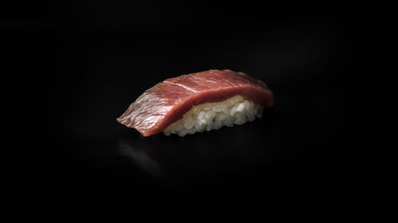 A sleek and elegant dark wagyu sushi slice artfully arranged on a black background, showcasing the rich texture and delicate flavors of gourmet cuisine.の素材