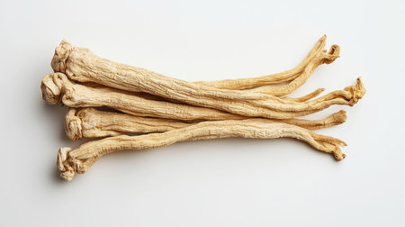 Cluster of dried ginseng roots isolated on a white background, photographed from above. The clean and minimalist setup emphasizes the natural contours.の素材