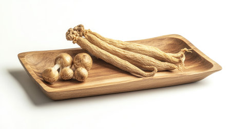 Close-up of a wooden tray with ginseng roots and Ganoderma mushrooms on a white background. Window shadow creates a natural look, perfect for herbal product advertising.の素材