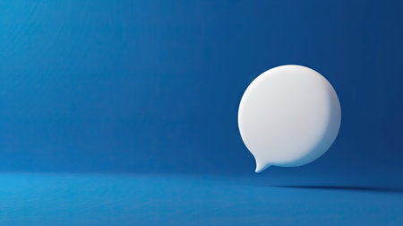 3D rendered white chat bubble on a rich blue background, ideal for illustrating conversation, text messaging, or dialogue in digital mediaの素材