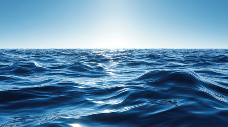 Deep blue ocean waves under a clear sky, sunlight reflecting on the water surfaceの素材