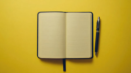 A minimalist scene of a blank lined notebook on a vibrant yellow background with a pen beside it, perfect for creative writing or note-taking projects.の素材
