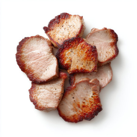 A close-up view of tender sliced barbecue pork chops showcasing charred edges against a white background, ideal for food portfolios and culinary projects.の素材