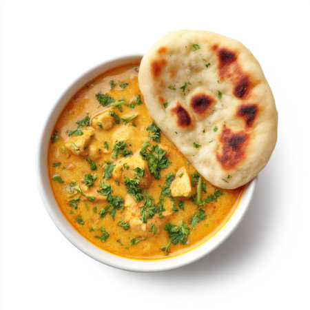 This image features a delectable bowl of creamy chicken curry topped with fresh herbs and served with soft naan bread. Perfect for food photography.の素材