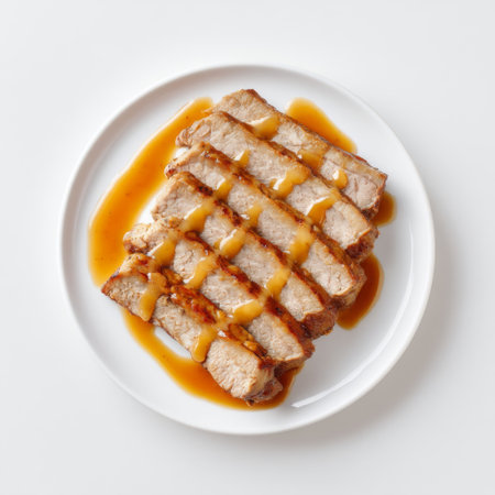 A tempting image showcasing sliced grilled meat drizzled with a savory sauce on a white plate, perfect for meal inspiration or culinary presentations.の素材