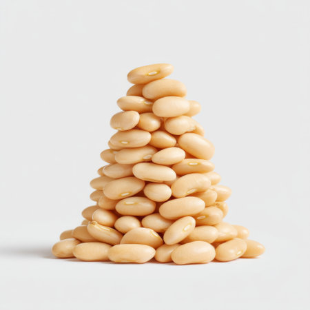 A neatly stacked pyramid of pale yellow beans on a white background, ideal for culinary projects or themes focused on healthy eating and nutrition.の素材