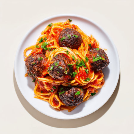 A mouthwatering plate of spaghetti topped with juicy meatballs and a rich tomato sauce, garnished with fresh herbs, perfect for any meal.の素材