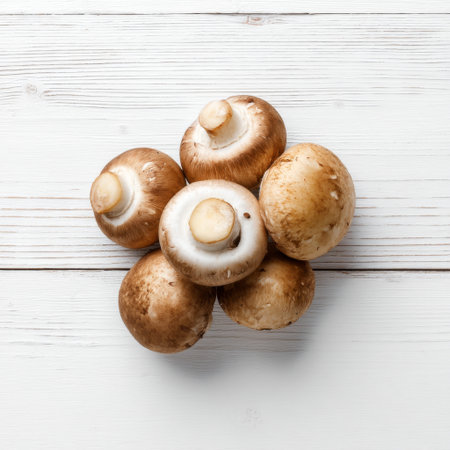 A close-up view of fresh, organic mushrooms arranged on a rustic white wooden table surface, perfect for culinary projects or healthy recipe themes.の素材