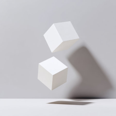 This image features simple white cubes suspended in mid-air, casting soft shadows against a light gray background, perfect for minimalistic design concepts.の素材