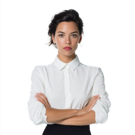 A confident woman wearing a white shirt poses with her arms crossed, showcasing a serious expression. The image captures elegance and self-assurance in a minimalist studio setting.の素材
