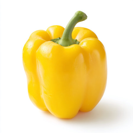 A bright and fresh yellow bell pepper stands alone against a clean white background, representing healthy eating and vibrant culinary ingredients.の素材
