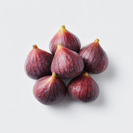 A visually appealing arrangement of fresh figs on a white background showcases their rich color and texture, emphasizing their natural beauty and health benefits.の素材