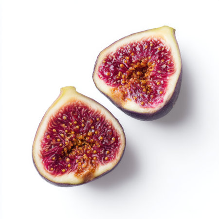 This image features freshly sliced fig halves showcasing their vibrant color and rich texture against a clean white background. Perfect for culinary projects.の素材