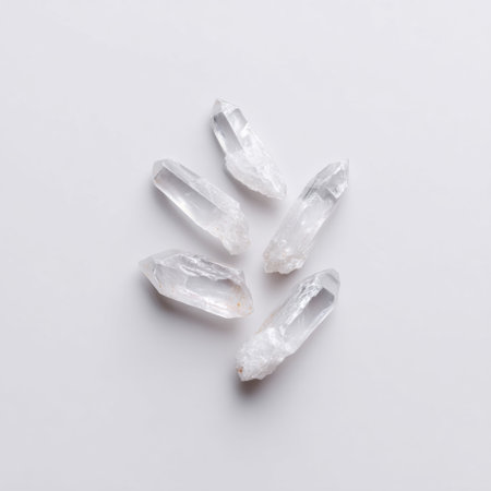 This captivating image features five stunning transparent quartz crystals arranged artistically on a soft light grey background, perfect for themes of natural beauty and healing.の素材