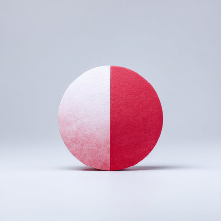 This image features a circular paper piece split in red and white on a smooth gray background, showcasing a striking contrast and modern design ideal for various creative projects.の素材