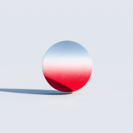 This image features a circular disc with a sleek gradient transition from vibrant red to reflective silver, casting a soft shadow on a light grey surface.の素材