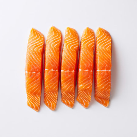 This image features vibrant, freshly sliced salmon fillets arranged neatly on a clean white background, perfect for showcasing culinary creativity.の素材