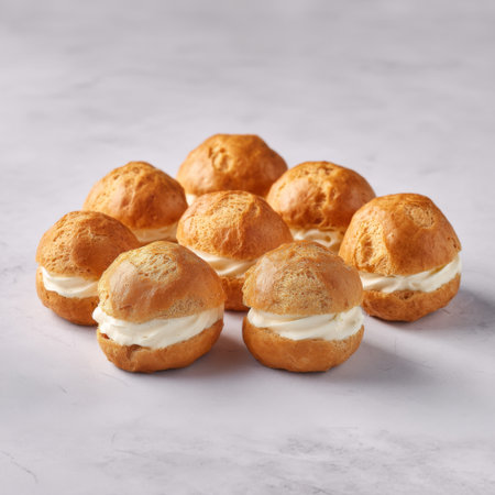 A tempting arrangement of freshly baked cream puffs with smooth cream filling, perfect for dessert lovers and culinary enthusiasts. Ideal for food photography.の素材