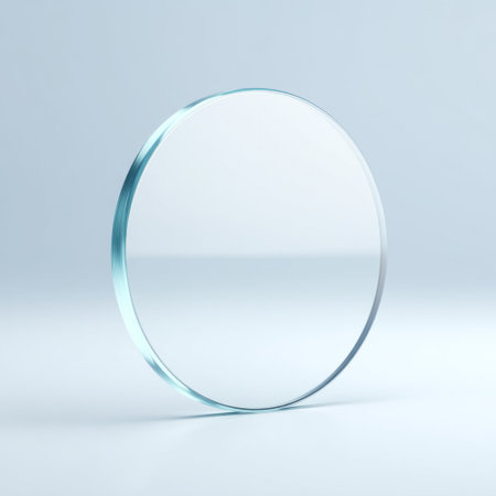 A visually appealing transparent glass disc rests on a softly lit blue background, showcasing its minimalistic design and perfect clarity.の素材