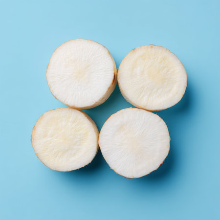 Fresh slices of radish showcase their clean, white texture against a vibrant blue backdrop, perfect for culinary creativity and healthy food trends.の素材