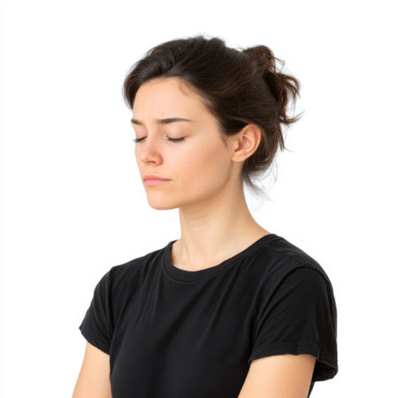A young woman captures a moment of mindfulness with her eyes closed, showcasing tranquility and self-reflection in a simple indoor environment.の素材