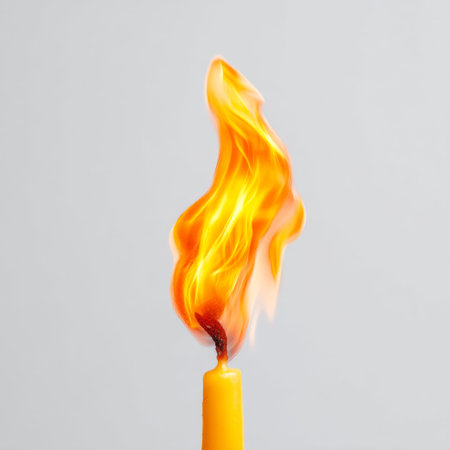 A captivating close-up of a vibrant orange flame dancing atop a yellow candle, set against a minimalistic background. The luminous glow creates an inviting and tranquil atmosphere, perfect for evoking warmth and serenity in various design projects.の素材
