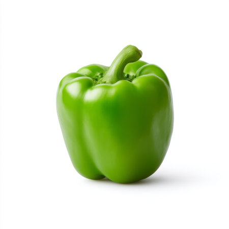 A vibrant green bell pepper isolated on a clean white background, showcasing its freshness and appeal for healthy cooking and culinary use.の素材