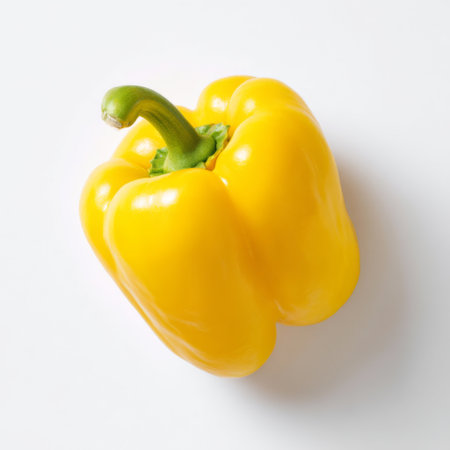 This image features a fresh yellow bell pepper against a pristine white backdrop, highlighting its vibrant color and smooth texture, ideal for culinary uses.の素材