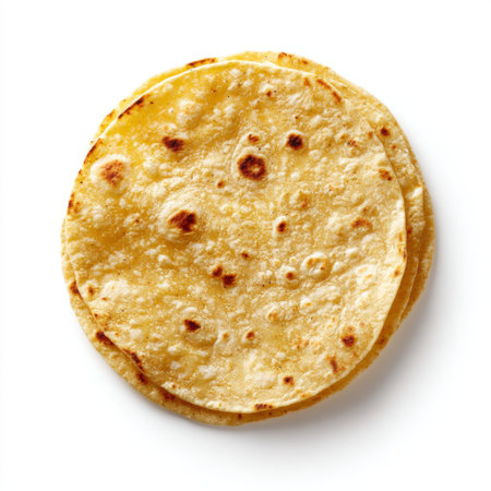 Close-up view of freshly made corn tortillas stacked neatly on a white background, ideal for food styling, recipes, and culinary projects.の素材