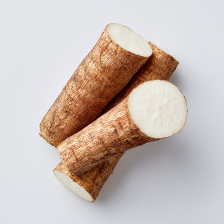 Fresh cassava roots arranged on a clean white background showcase the natural beauty of this nutritious tuber. Ideal for cooking and healthy recipes.の素材