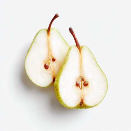 Two freshly sliced green pear halves reveal juicy flesh and natural seeds, ideal for food styling, recipes, and healthy eating promotions.の素材