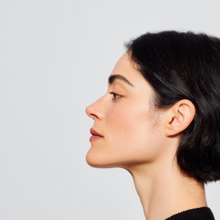 This profile image captures a woman showcasing her smooth skin and natural makeup in soft light, emphasizing beauty and elegance, ideal for fashion-related projects.の素材