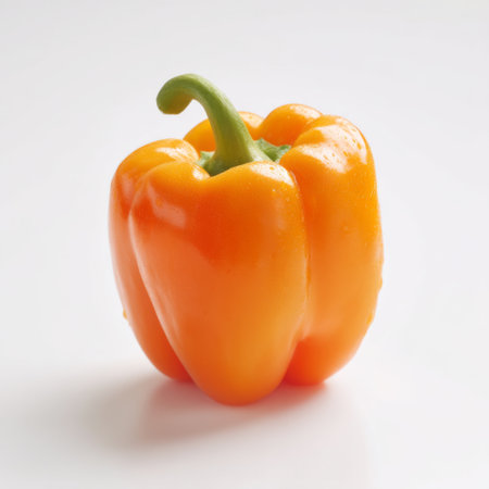 A bright yellow bell pepper stands prominently against a clean white background, showcasing its vibrant color and fresh appearance, ideal for culinary projects.の素材