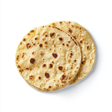 This image features freshly cooked Indian flatbread resting on a clean white surface, showcasing its unique texture and inviting appearance. Perfect for culinary projects or menus.の素材