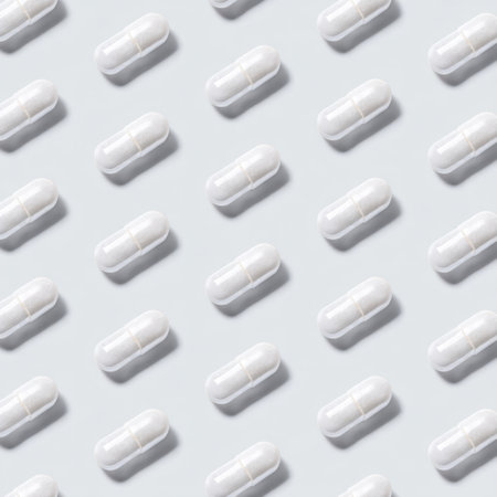 A visually appealing arrangement of white capsules on a light surface, perfect for health, wellness, and pharmaceutical themes in promotional materials.の素材