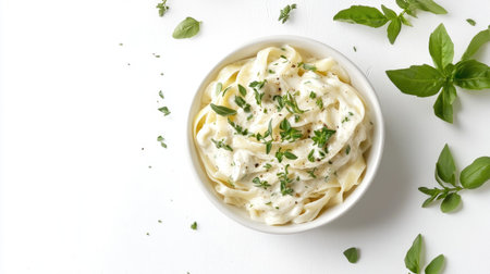 An overhead shot of creamy fettucine styled elegantly in a bowl, garnished with fresh herbs. Perfect for showcasing Italian culinary delights and comfort food.の素材