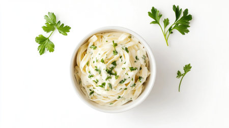 Discover a stunning overhead view of creamy fettuccine served in a white bowl, garnished with fresh herbs, perfect for any culinary presentation.の素材