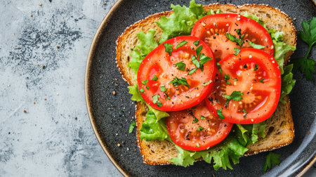 A vibrant sandwich showcasing fresh tomatoes and crisp lettuce on toasted rye bread, perfect for a healthy snack or light meal.の素材