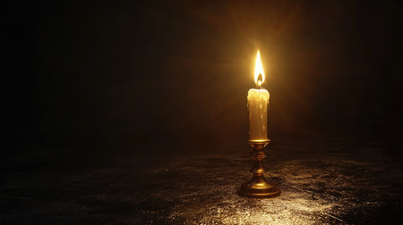 A warm candlelight flickers softly in a dark setting, creating a serene and peaceful ambiance. Ideal for concepts of relaxation, meditation, and tranquility.の素材