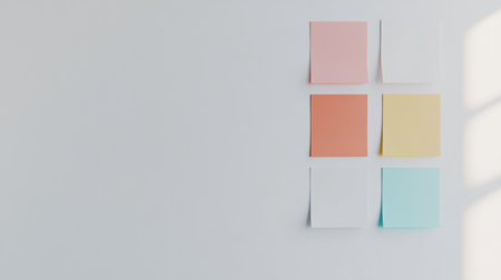 A collection of colorful sticky notes arranged on a white wall, creating a minimalist and aesthetic look ideal for planning and reminders in any workspace.の素材